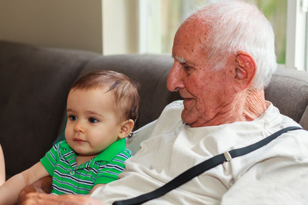 Cute baby boy with great grandfather in a home setting.の写真素材