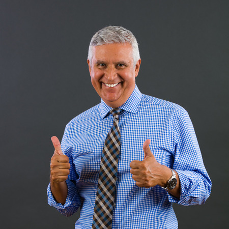 Handsome middle age business man portrait on a gray background.の写真素材