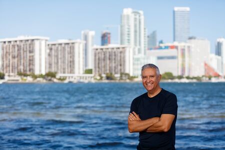 Handsome middle age man outdoor portrait with a downtown bay skyline background.の写真素材