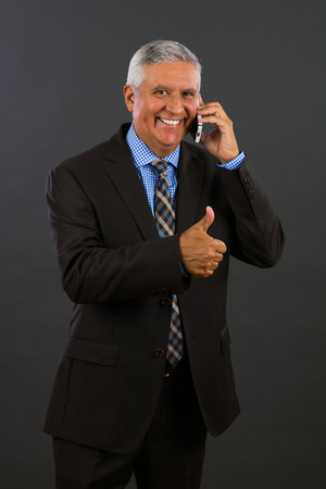 Handsome middle age business man portrait on a gray background.の写真素材