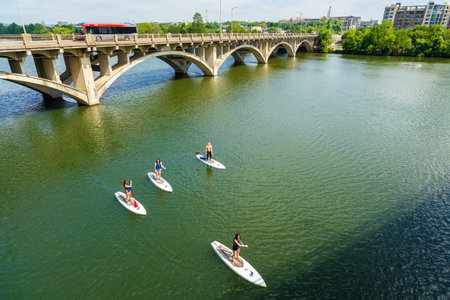 Austin, TX USA - April 14: Skyline view of the downtown area along the Colorado River with paddle boarders cruising by.のeditorial素材