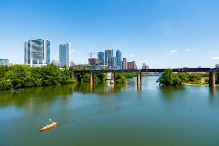 Austin, TX USA - April 14: Skyline view of the downtown area along the Colorado River with kayakers cruising by.のeditorial素材