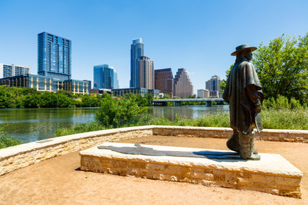 Austin, TX USA - April 14, 2016: Skyline view of the downtown district along the Colorado River with the statue of the late Stevie Ray Vaughan.のeditorial素材