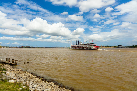 New Orleans, LA USA - April 20, 2016: The Mississippi River with departing paddle boat viewed from the French quarter.のeditorial素材