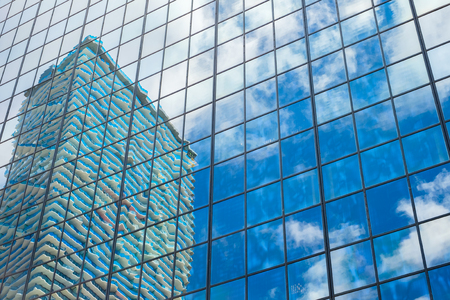 Reflection of a apartment hi rise building on a glass office building in a downtown urban area.