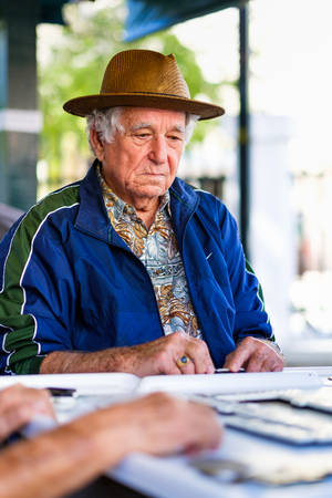 Miami, FL USA - January 11, 2017: Unidentified elderly man in deep concentration as he plays the domino game in the historic Domino Park in popular Little Havana.のeditorial素材