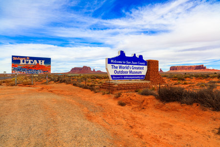 Monument Valley, Utah USA - November 1, 2016: The colorful Welcome to Utah and San Juan County signs with the natural beauty of the red sandstone buttes in the background.のeditorial素材