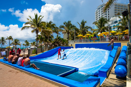 Hollywood Beach, Florida - July 6, 2017: Young visitor enjoying the wave riding flowrider attraction at the Margaritaville Resort, a popular tourist destination in Broward County.のeditorial素材