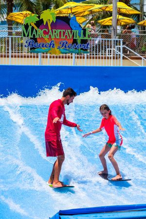 Hollywood Beach, Florida - July 6, 2017: Young visitor enjoying the wave riding flowrider attraction...