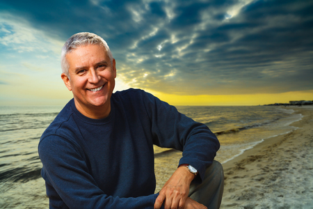Handsome middle age man outdoor portrait with a beach background at sunset.の写真素材