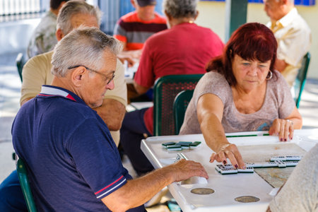 Miami, Florida - February 12, 2018: Unidentified elderly individuals play the domino game in the historic Domino Park in popular Little Havana.のeditorial素材
