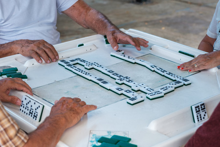 Close up view of individuals playing the domino game in the historic Domino Park in popular Little...