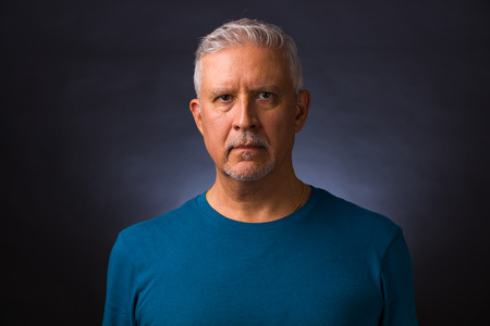 Handsome middle age man studio portrait with a gray background.
