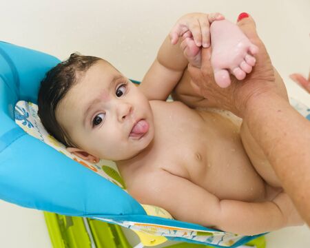 Beautiful seven month old baby girl portrait in a home setting being bathed.