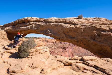 Moab, Utah USA - October 18, 2019: Tourist  enjoying the natural beauty of the Mesa Arch in Canyonlands National Park.のeditorial素材