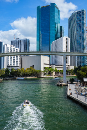 Miami, Florida USA - January 30, 2021: Downtown skyline cityscape with tall skyscrapers and boats cruising the river in the Brickell district.のeditorial素材