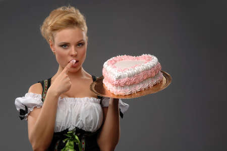 Pretty housewife with a big cake on a platterの写真素材