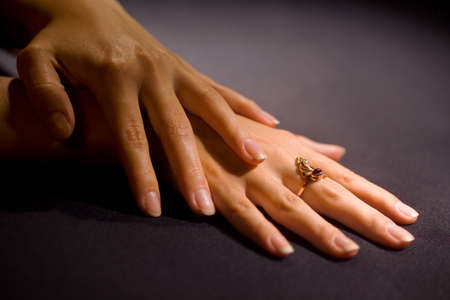 woman's hand with a ring on his finger on the tableの写真素材