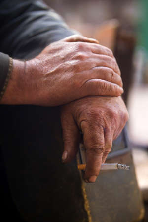 hand working with a cigarette and a protective helmetの写真素材