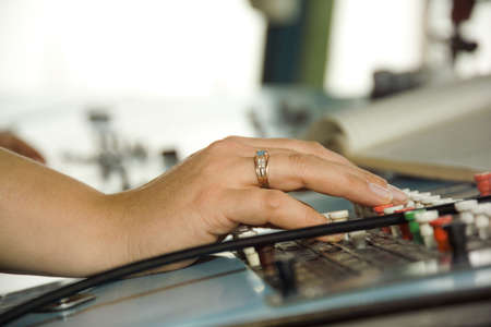 woman's hands on the remote control in an industrial plantの写真素材