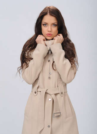 beautiful girl in a coat on a white backgroundの写真素材
