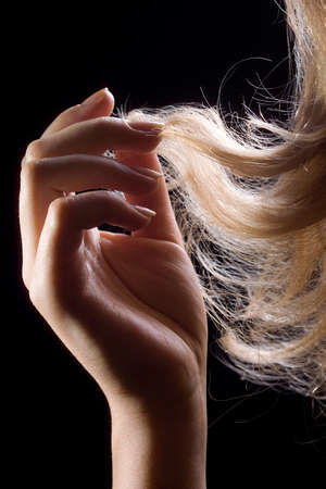women's hands on the hair on a dark backgroundの写真素材