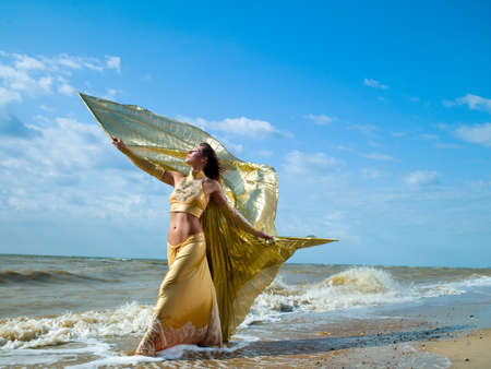 girl walking on the beach in a beautiful dressの写真素材