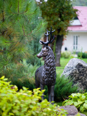 sculpture of a deer from the metal into the trees with sunlightの写真素材
