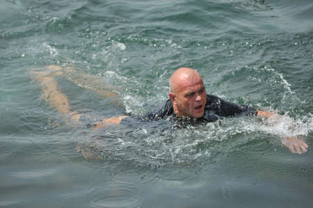 man in dark clothes floating in the seaの写真素材