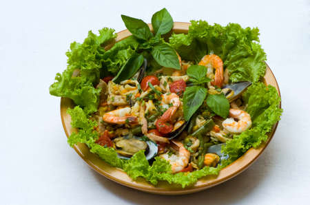 Seafood salad on a plate with green leavesの写真素材