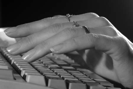 Women's gentle hand with a manicure at the computerの写真素材
