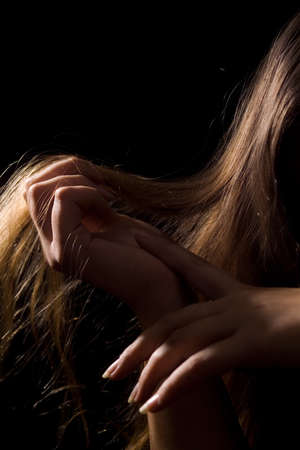 Photo of female hands on a black background holding hands in vvolosyの写真素材