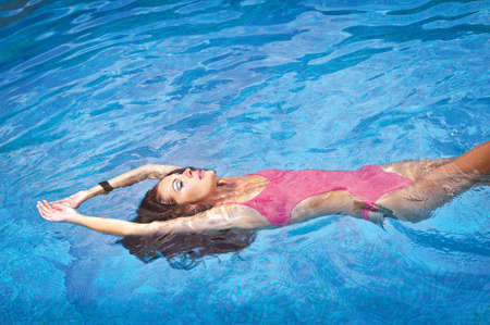 photo of a girl with beautiful make-up in a bathing suit on the water