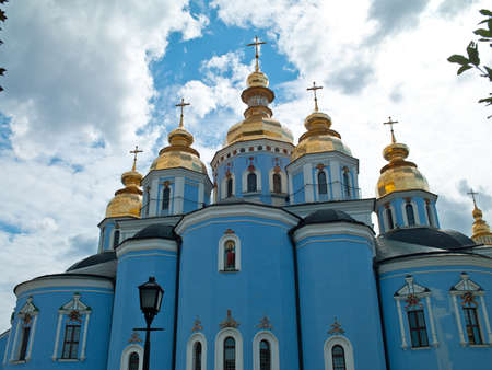 Photo of Orthodox church with golden domes on a background of sky and clouds