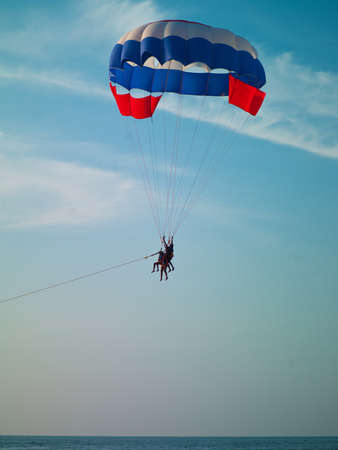 a man who flies on a parachute over the seaの写真素材