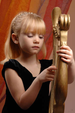 picture of a little girl who plays the harp and poses for the cameraの写真素材