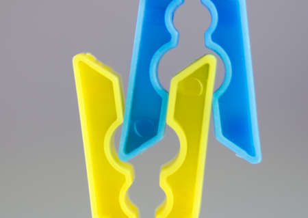 Clothespins for bedya blue and yellow color on a background of isolationの写真素材