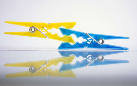 Clothespins for bedya blue and yellow color on a background of isolationの写真素材