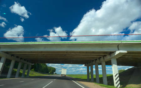 Highway and bridge against the sky with clouds