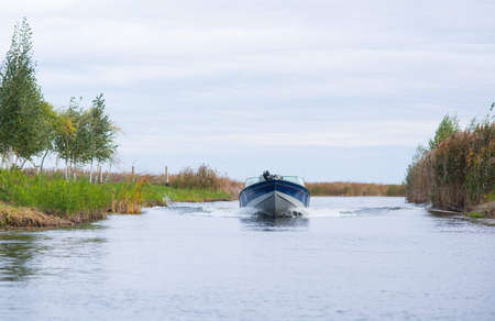 Aluminum Motor boat on a lake on a sky backgroundの写真素材