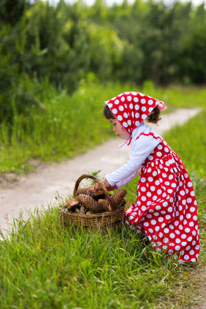 Little girl with mushrooms in the forest.の写真素材