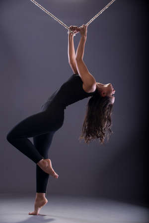 Girl in black clothes with a rope at the top.