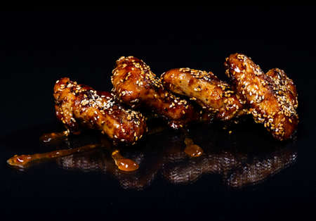 Chicken wings with honey on a black background.の写真素材