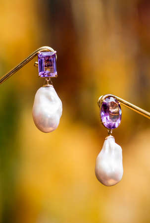 Jewelry, lilac earrings on a mannequin and on a blurred background.の写真素材