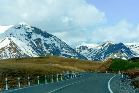 Caucasus mountains and road on a background of blue clouds. Georgia.