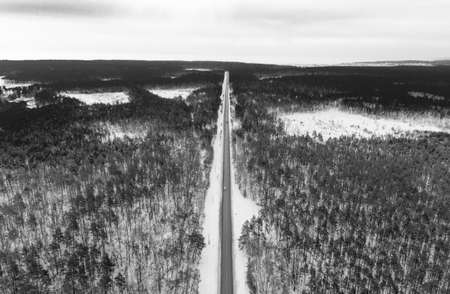 A car on the track and a forest in winter aerial view.の写真素材