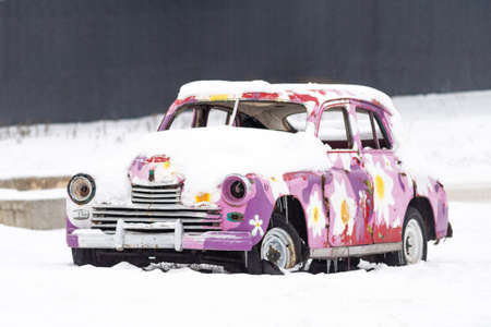 Vintage colored car under the snow.の写真素材