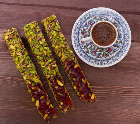 Oriental sweets and coffee on a wooden stand, top view.