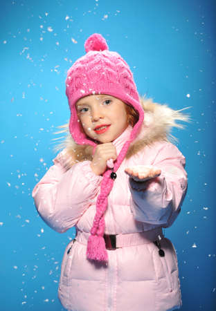 Little girl in winter clothes and snow.の写真素材