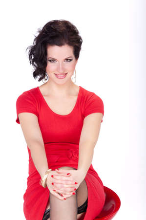 Beautiful brunette woman in a red dress on a white background.の写真素材